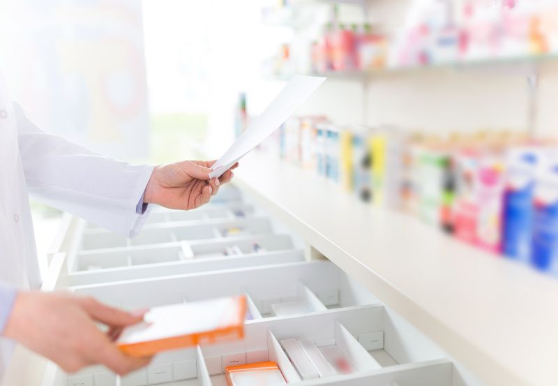 Apothekerin holt Medikamente aus einer Lade