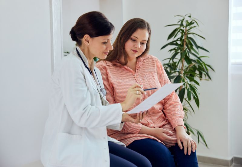 Ärztin spricht mit übergewichtiger Patientin