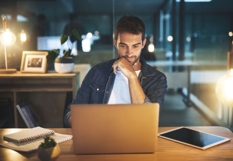 Mann arbeitet in der Nacht auf dem Laptop