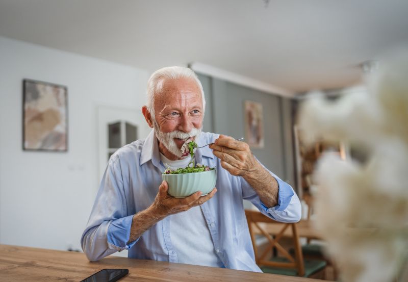 Älterer Herr isst einen Salat