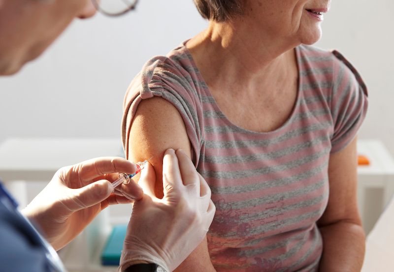 Ältere Frau bekommt Impfung in den Oberarm