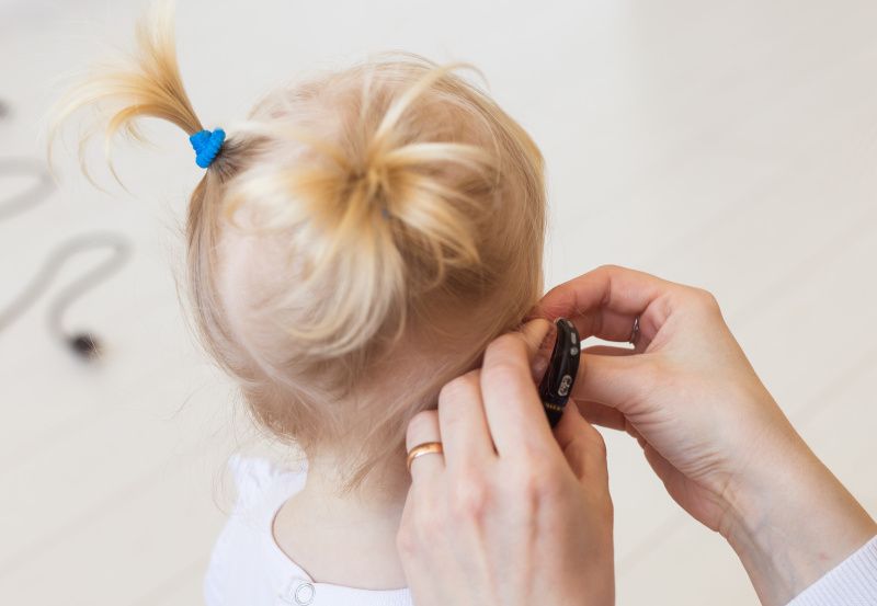 Mädchen bekommt Hörgerät