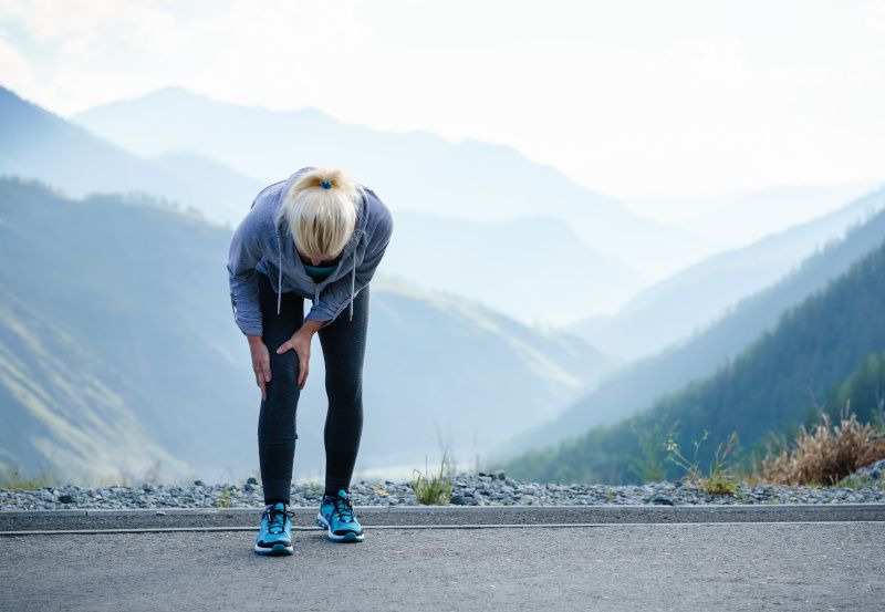 Frau mit Knieschmerzen beim Laufen