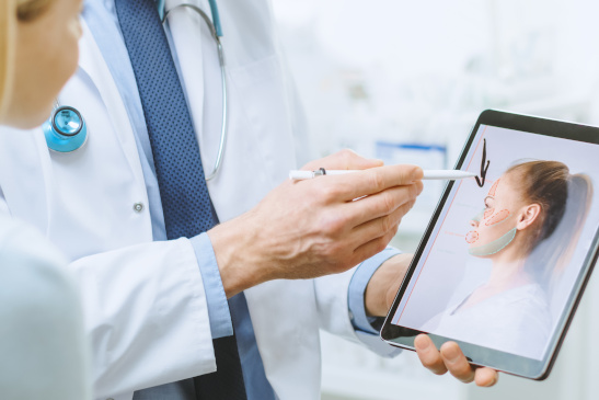 Arzt spricht mit Patientin über eine Schönheitsoperation