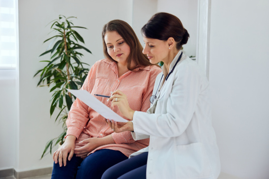 Ärztin spricht mit übergewichtiger Patientin