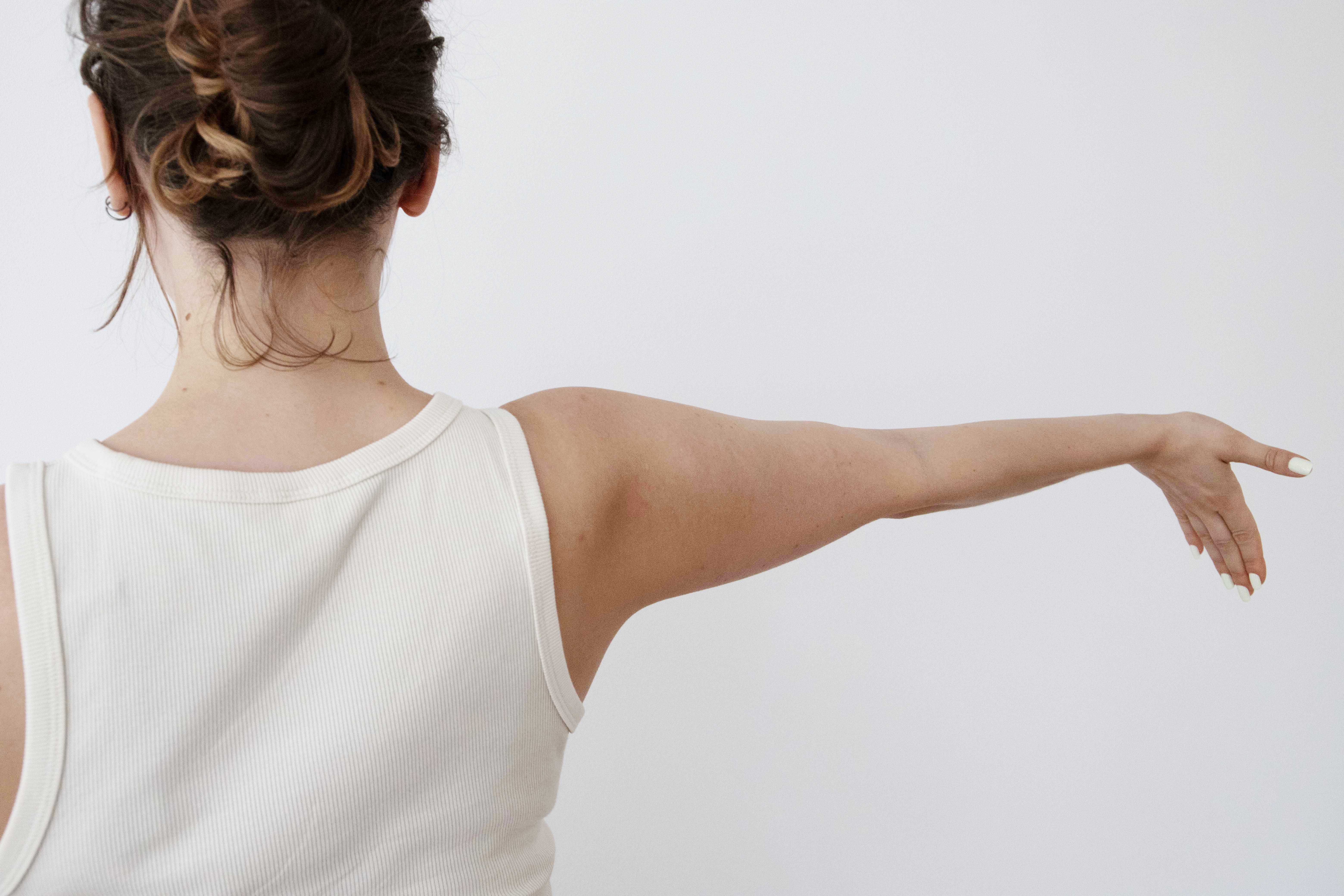 Frau streckt Arm aus und zeigt mit der Hand Richtung Boden
