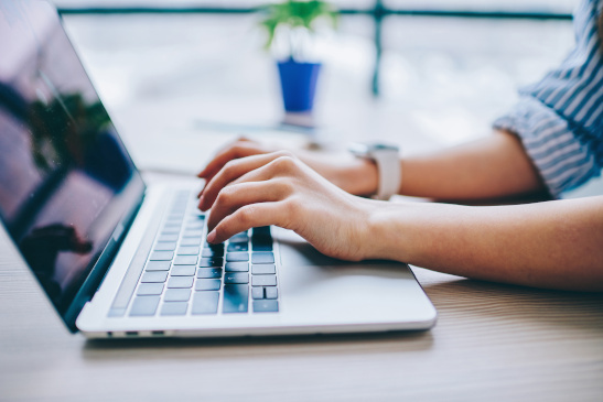Hände einer Frau an einem Laptop