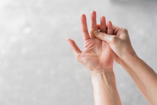 Hände einer Frau mit Schmerzen in den Fingergelenken