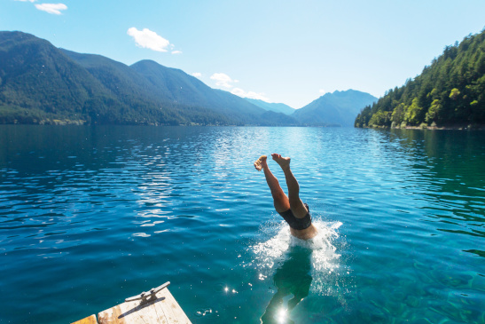 Mann macht einen Kopfsprung in einen See