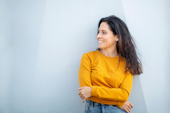 Frau steht vor einer blauen Wand