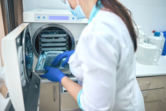 Frau sterilisiert medizinische Instrumente