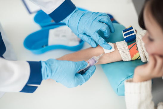 Arm eines Mädchens bei der Blutabnahme