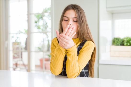 Mädchen hat Schmerzen im Handgelenk