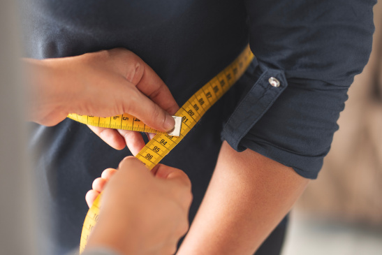 Maßband um den Bauch einer Person