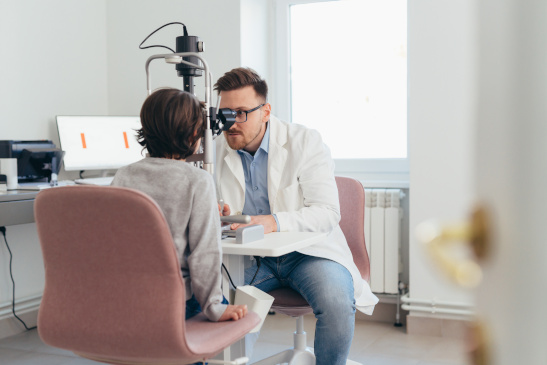 Augenarzt untersucht Augen eines Buben