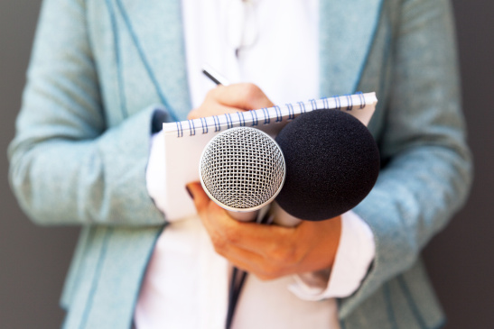 Journalistin mit Mikrofon und Notizblock