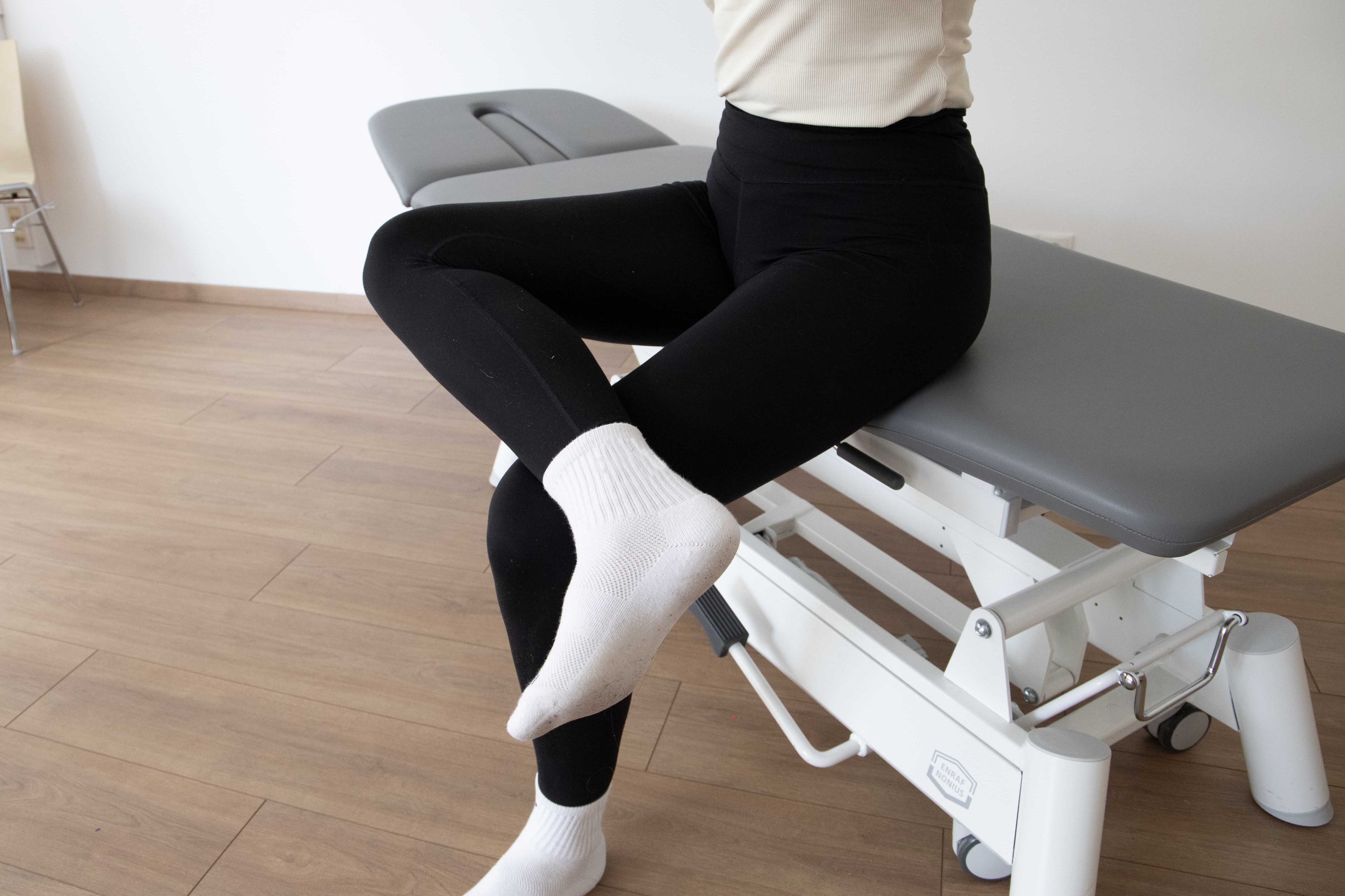 Frau in aufrechter Sitzposition, ein Bein in Schneidersitzposition