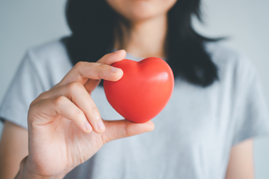 Frau hält rotes Herz in der Hand