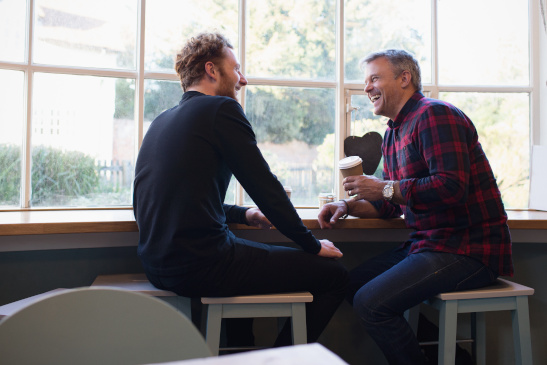 Zwei Männer unterhalten sich in einem Kaffeehaus
