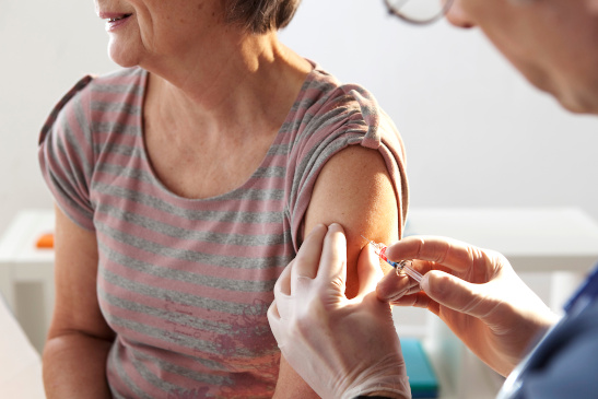 Ältere Frau bekommt Impfung in den Oberarm