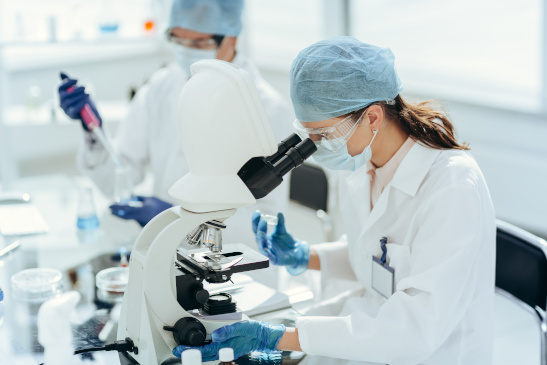 Frau in einem Labor arbeitet mit einem Mikroskop