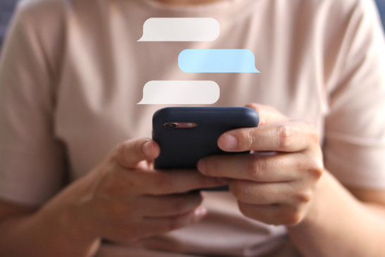 Frau spricht auf dem Smartphone mit einem Chatbot
