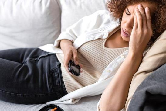 Frau mit Unterzuckerung auf der Couch
