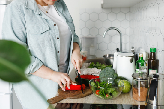 Frau bereitet Salat und Gemüse zu